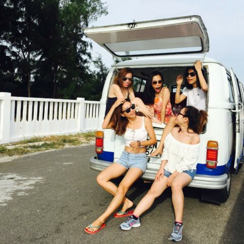 A group of young women sit in the back of a van on spring break