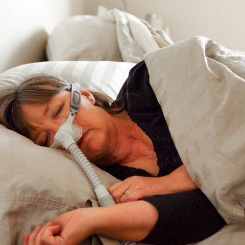 A woman sleeping with a CPAP machine